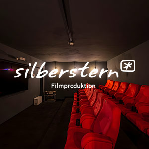 Silberstern Logo in Weiß auf einer Foto des kleinen Kinosaals von Silberstern.