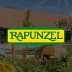 Rapunzel Logo im Vordergrund, der Standort im Hintegrund.